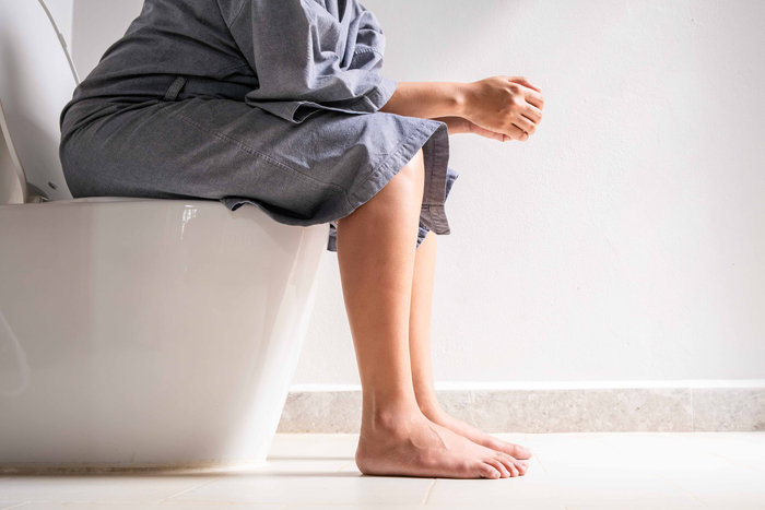Person mit Morbus Crohn sitzt auf der Toilette